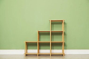 İçerideki zeytin duvarının yanındaki boş ahşap raf ünitesi.