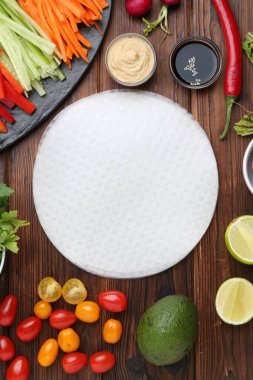 Yenebilir pirinç kağıtları ve malzemeler ahşap masada, düz yerde.