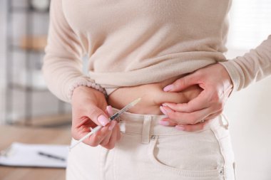 Kadın karnına insülin enjekte ediyor, yakın plan. Diyabet