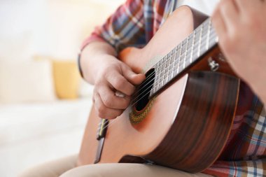Evde gitar çalan adam, eline odaklan.