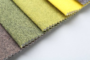 Beyaz arka planda farklı kumaş örnekleri, yakın plan. Metin için boşluk