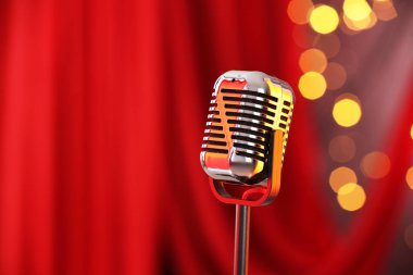 Kırmızı perdeye karşı bir klasik mikrofon, mesaj için yer. Bokeh etkisi