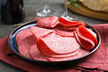 Gri masada servis edilen lezzetli sosisler, yakın plan.