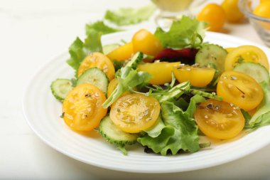 Beyaz masada sarı domatesli taze salata, yakın plan.