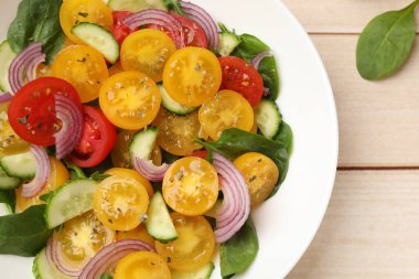 Tahta masanın üstünde sarı domatesli taze salata, üst manzara.