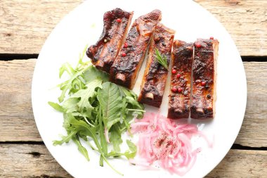 Lezzetli domuz pirzolası, roka ve soğan ahşap masa, üst manzara.