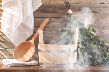 Sauna ekipmanları. Kova, kepçe, çırpı ve havlular buharda
