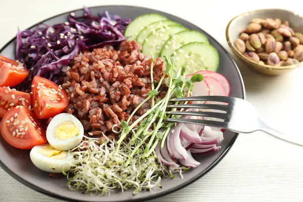 Beyaz masada servis edilen kahverengi pirinçli lezzetli salata, yakın plan.