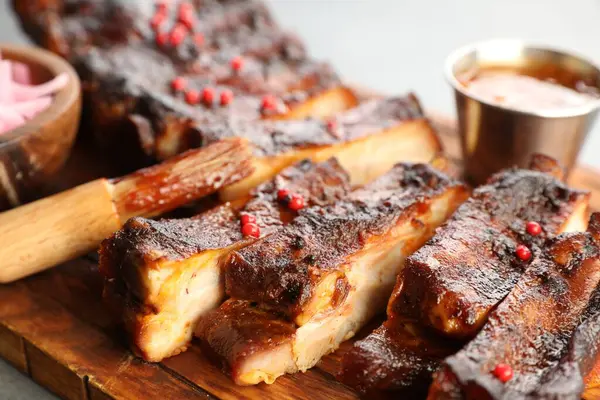 Lezzetli domuz pirzolası ve gri masada fırça, yakın plan.