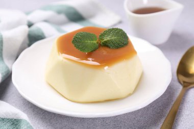 Karamel soslu lezzetli puding ve nane şekeri, yakın plan.