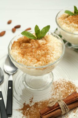 Tarçınlı, naneli, bademli ve kaşıklı lezzetli sütlaç, yakın plan.