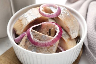 Beyaz masada soğanlı lezzetli ringa balıkları, yakın plan.