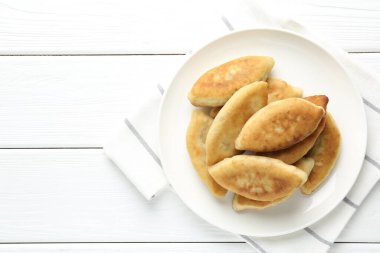 Beyaz ahşap masa üzerinde nefis kızarmış pirizky (doldurulmuş turtalar), üst manzara. Metin için boşluk