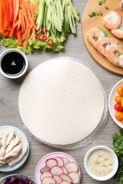 Pirinç kağıt çarşaflar ve gri ahşap masa üzerindeki farklı malzemeler.