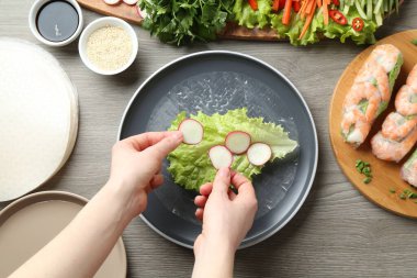 Gri ahşap masada nefis börek yapan bir kadın.