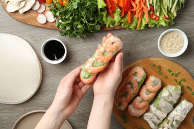 Gri ahşap masada nefis börek yapan bir kadın.