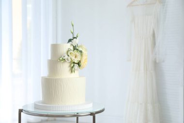 İçerideki masada çiçek desenli nefis düğün pastası, mesaj için yer var.