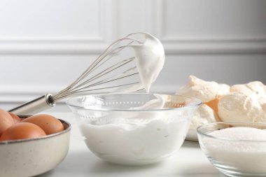 Krem şantili çırpma çırpma ve diğer malzemeler ışık masasında, yakın plan. Kurabiye pişiriyorum.