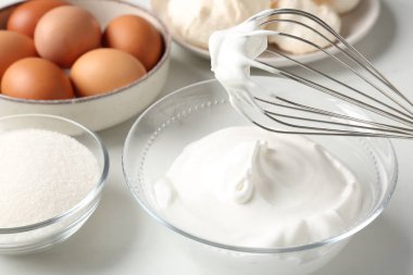 Krem şantili çırpma çırpma ve diğer malzemeler ışık masasında, yakın plan. Kurabiye pişiriyorum.