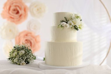 Çiçekli düğün pastası ve kapalı masa desenli lezzetli bir pasta.