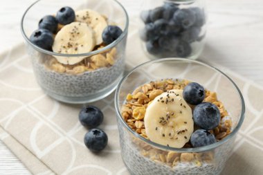 Chia tohumlu lezzetli tatlı, yoğurt, granola, yaban mersini ve muz, yakın plan. Süper yemek.