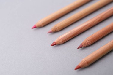 Açık gri arkaplanda pek çok farklı dudak kalemi, yakın plan