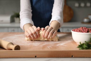 Khinkali yapıyorum. Mutfakta hamur yoğuran kadın, yakın plan.