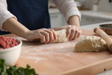 Khinkali yapıyorum. Mutfakta hamur yoğuran kadın, yakın plan.