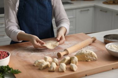 Khinkali yapıyorum. Mutfaktaki masada hamur şekillendiren kadın, yakın plan.
