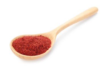 Tahta kaşıkta kırmızı biber tozu, beyaz kaşıkta izole edilmiş.