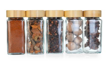 Beyaz kavanozlardaki farklı aromatik baharatlar.