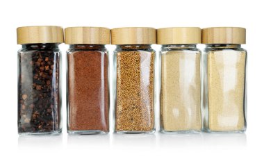 Beyaz kavanozlardaki farklı aromatik baharatlar.