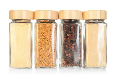 Beyaz kavanozlardaki farklı aromatik baharatlar.