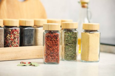 Açık gri masadaki kavanozlardaki farklı aromatik baharatlar.