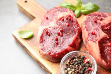 Gri masada çiğ et ve baharat parçaları, yakın plan.