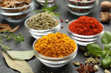 Gri masada farklı aromatik baharatlar, yakın plan.