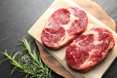 Çiğ et parçaları ve baharatlar siyah masanın üzerinde, düz yatıyordu.