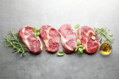 Çiğ et parçaları ve baharatlar gri masada, düz yatıyordu.