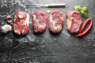 Çiğ et, baharat ve çatal. Koyu masada, düz yerde. Metin için boşluk