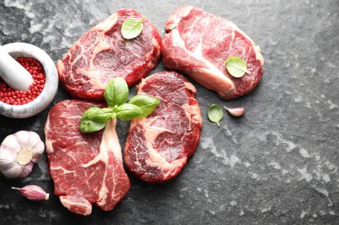 Koyu masa üzerinde çiğ et ve baharat parçaları, düz. Metin için boşluk