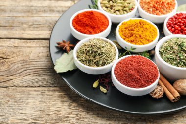 Ahşap masada farklı aromatik baharatlar, yakın plan. Metin için boşluk