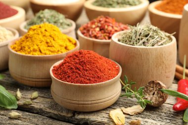 Ahşap masada farklı aromatik baharatlar, yakın plan.