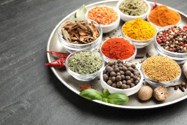 Siyah masada farklı aromatik baharatlar, yakın plan. Metin için boşluk