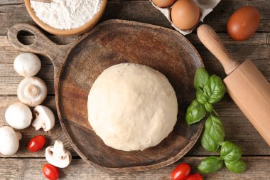 Pizza yapıyorum. Tahta masadaki farklı malzemeler.