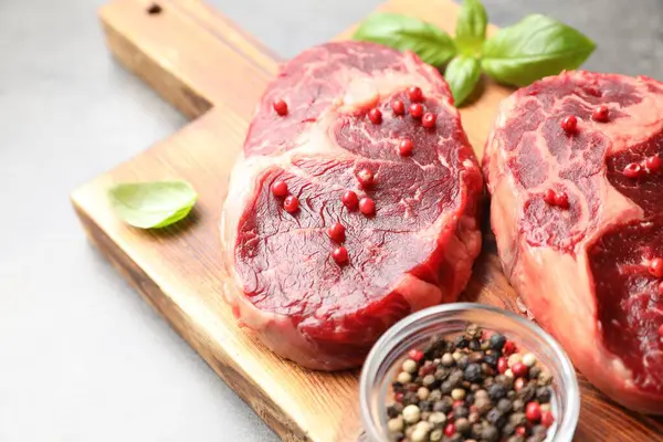 Gri masada çiğ et ve baharat parçaları, yakın plan.