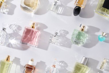 Hafif arka planda çeşitli parfüm şişeleri, düz yatıyordu.