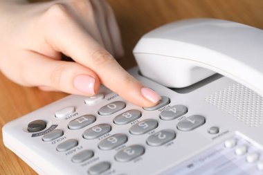 Ahşap masada telefonla arayan kadın, yakın plan.