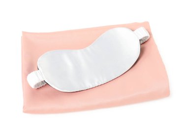 Pembe ipeksi yatak örtüleri ve beyaz arka planda uyku maskesi.