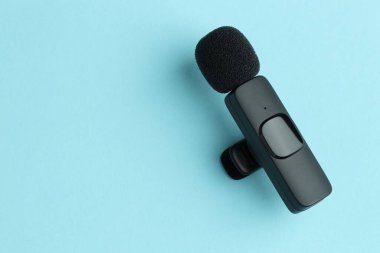 Açık mavi arka planda Lavalier mikrofonu, üst manzara. Metin için boşluk