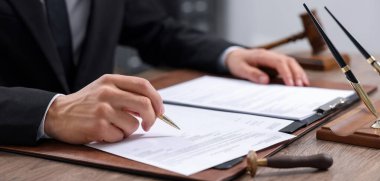 Yargıç ahşap masada belge imzalıyor, yakın plan. Pankart tasarımı